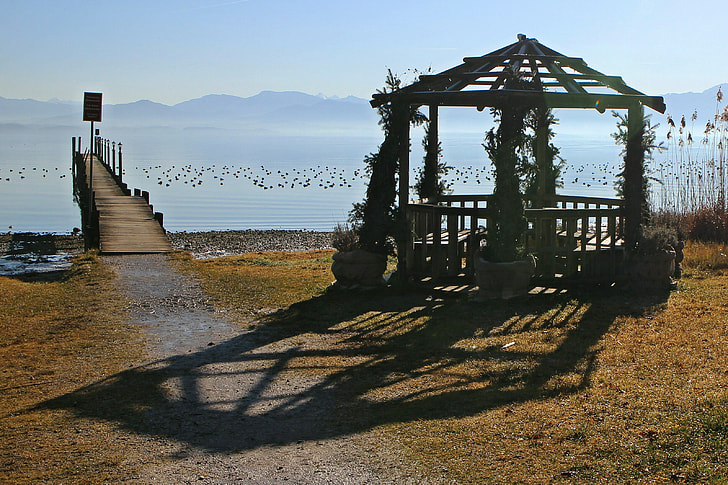 brown wooden gazebo beside body of water during daytime