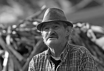 grayscale photo of man wearing hat and button-down shirt thumbnail