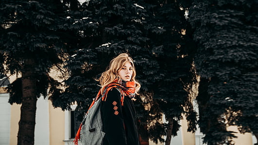 woman in black jacket standing in front of trees thumbnail
