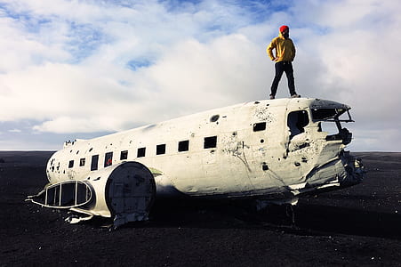 man wearing yellow top on top of white steel air plane thumbnail