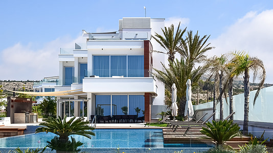 white concrete house near body of water thumbnail