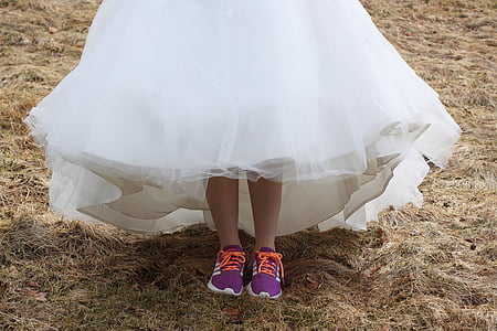 woman in white wedding gown wearing purple running shoes thumbnail