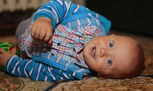 boy in blue jacket lying on the carpet thumbnail