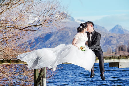 bridge and groom kissing on bridge during daytime thumbnail