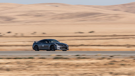 black sports car on gray concrete road at daytime thumbnail