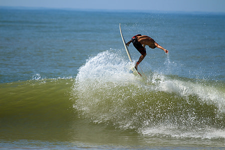 man surfboarding on sea during daytime thumbnail
