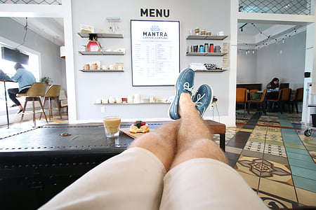 person's feet on black wooden table thumbnail