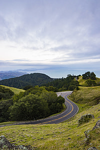 grey top road between green grass field on daytime thumbnail