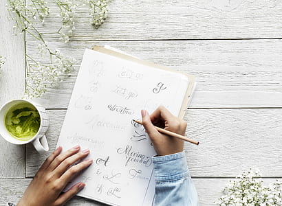 person writing calligraphy on paper thumbnail