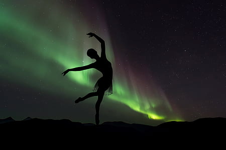 silhouette photography of ballet dancer in northern lights thumbnail