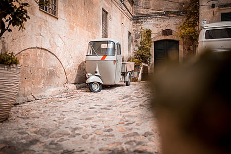 grey and white auto rickshaw parked near doorway during daytime thumbnail