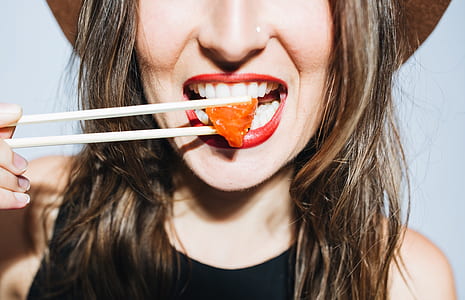 woman eating meat dish using chopsticks thumbnail