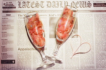 two clear wine glasses on newspaper] thumbnail