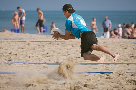 man catching white ball in seashore thumbnail