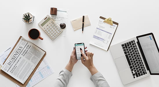 person using smartphone near laptop thumbnail