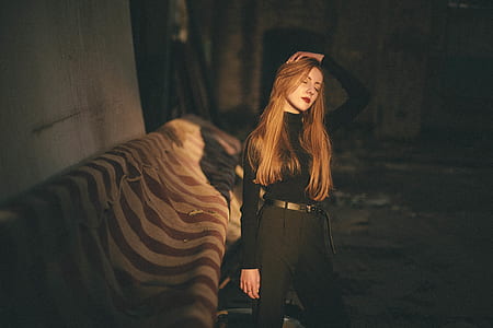 woman wearing black long-sleeved top and bottoms while closing her eyes beside brown striped textile thumbnail