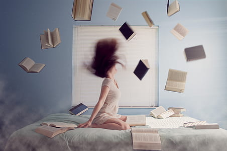 photo of woman in bed with flying books thumbnail