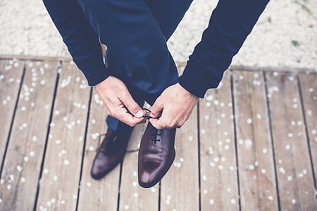 man lacing up his brown leather oxford shoe on the right side thumbnail