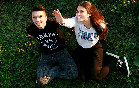 man and woman sitting on grass field thumbnail