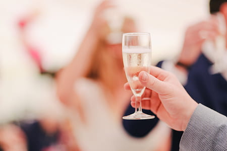 person holding clear wine glass close-up photography thumbnail