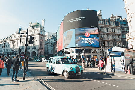 Classic Teal Car on Road Surrounded by People Near Building With Led Monitor Displaying Turkish Airlines during Daytimne thumbnail