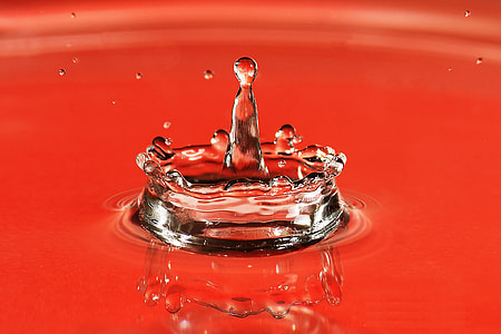 Closeup shot of a water drop splash on red background thumbnail