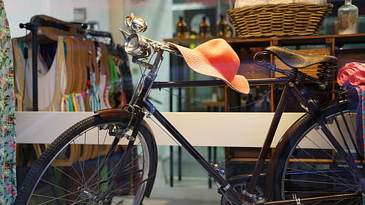 orange sun hat on bicycle handlebar thumbnail