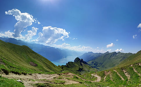 lush valley near river under blue cloudy sky at daytime thumbnail