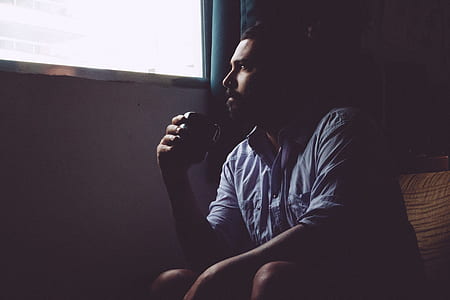 man sitting inside room holding mug thumbnail