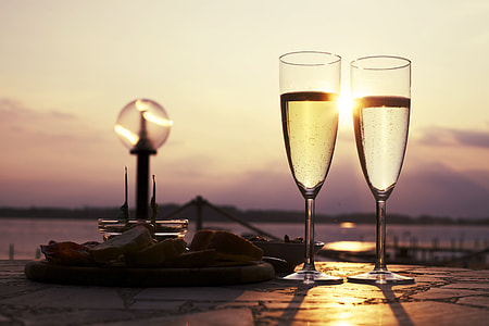 two long-stem wine glasses beside body of water photography thumbnail