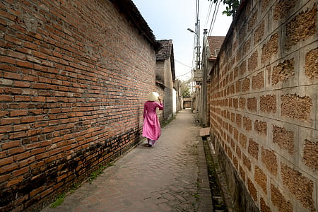 person standing near brown brick wall thumbnail