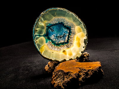blue and brown geode on brown rock thumbnail