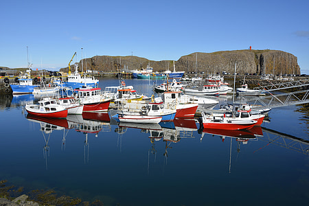 red and white boats on body of water near hill thumbnail
