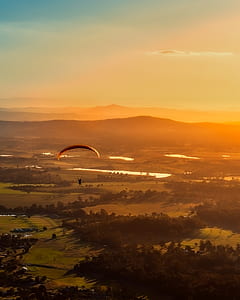 person paragliding above green trees thumbnail