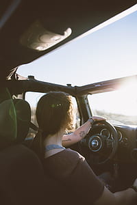 woman wearing brown shirt while sitting down inside vehicle during daytime thumbnail
