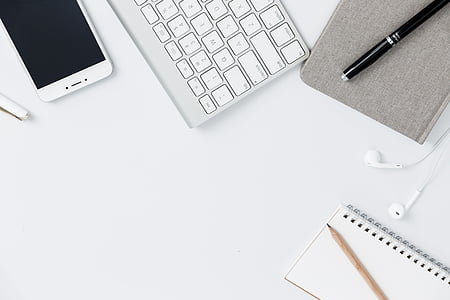 white smartphone beside white wireless keyboard and black pen thumbnail