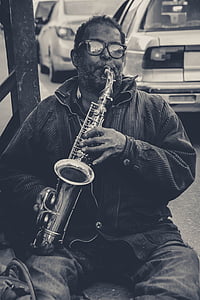 grayscale photo of man playing saxophone thumbnail