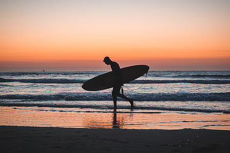 person holding surfboard near sea shore thumbnail
