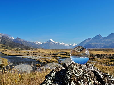clear glass paperweight on brown rock under blue sky during daytime thumbnail