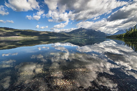landscape photography of mountains surrounded by body of water during daytime thumbnail