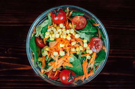 tomatoes, carrots, and leaf vegetable in round clear glass bowl thumbnail