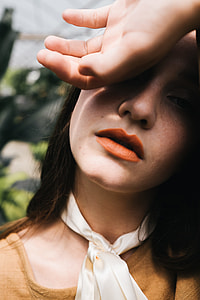 photo of woman with left hand on forehead during daytime thumbnail