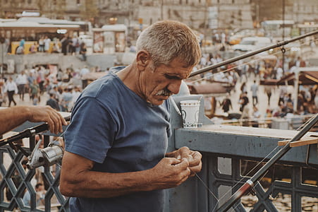 man standing while looking at fishing rod thumbnail