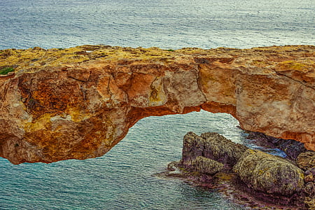 brown rock formation near shore thumbnail