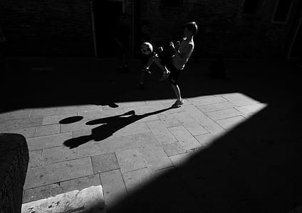 grayscale photography of boy playing soccer ball thumbnail