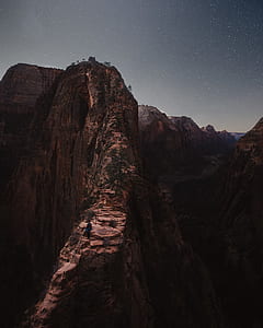 person standing on mountain under starry night thumbnail