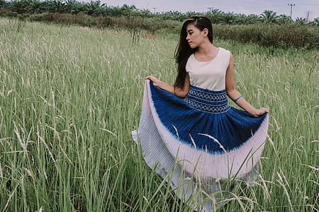woman holding her dress standing in grass thumbnail