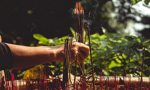 person holding lighted incense thumbnail