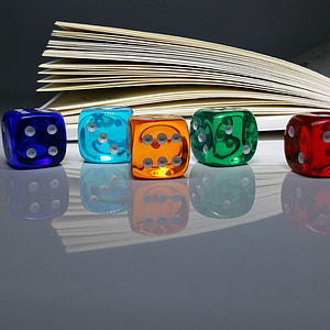 five assorted-color dices near book thumbnail