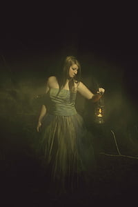 woman wearing gray strapless gown holding black lantern thumbnail